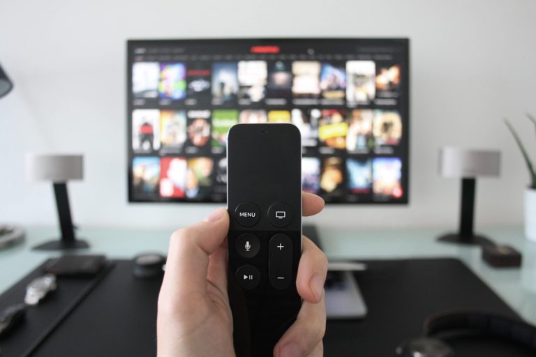 tv remote with tv apps screen in background